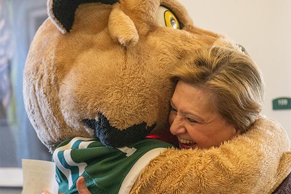 President Gonzalez hugs Rufus the bobcat.