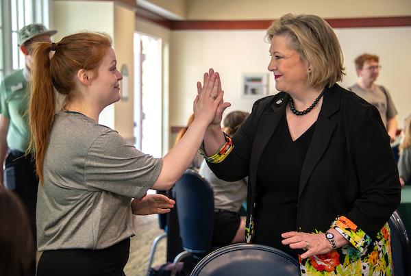 President Gonzalez high fives a student.