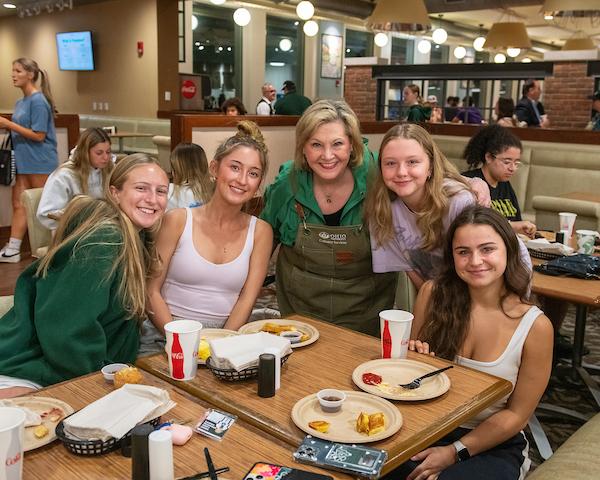 President Gonzalez poses with a group of students in the dining hall.