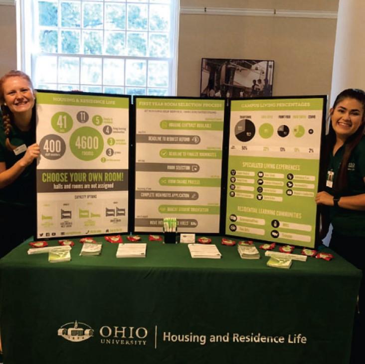 Housing Ambassadors at a Resource fair by a tri-fold about Housing information