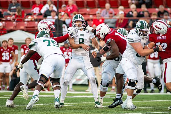 Ohio redshirt junior quarterback Nick Poulos is swarmed by Miami defenders after throwing a pass in the fourth quarter of the Battle of the Bricks.