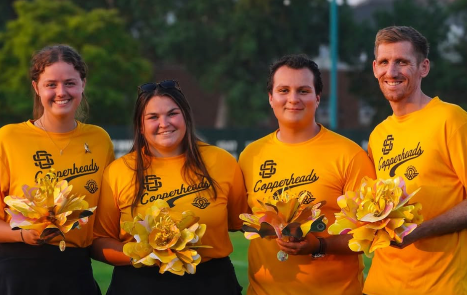 Copperheads staff smiling holding yellow Passion Works flowers