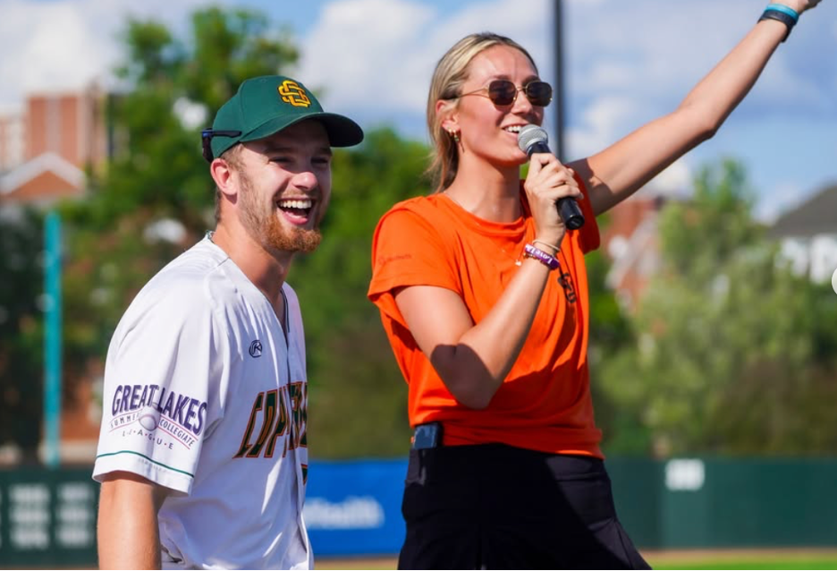 A Copperheads Baseball staff announcing at a game with a microphone 