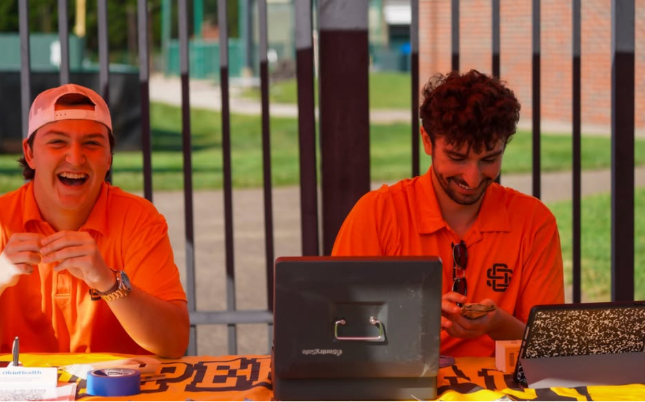 Copperheads baseball staff laughing while working at a merch table