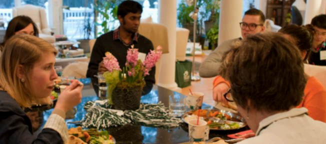 Group of students sharing a meal with alumni