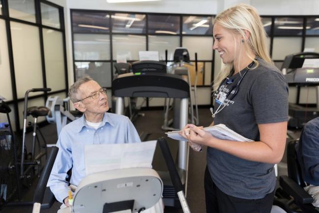 A student exercise technician works with a patient in HeartWorks.