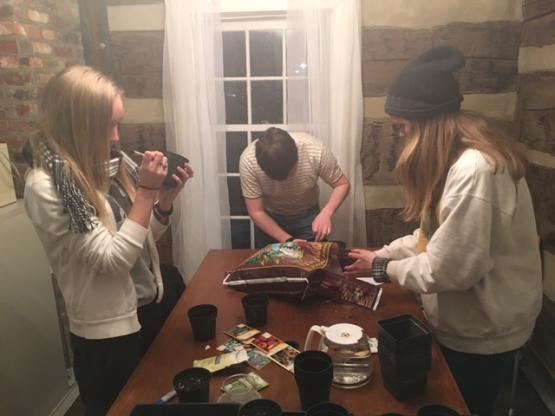 Students gather to plant seeds at the dinning room table.