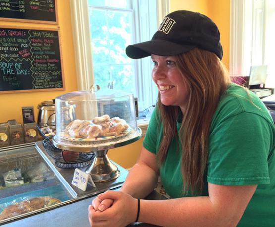 A student smiling, working at the Ridges Cafe