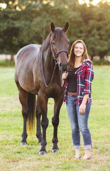 A equine studies student stands with a horse