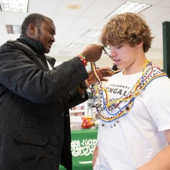 Diversity Leadership Ambassador putting beads on a student at a multicultural fair