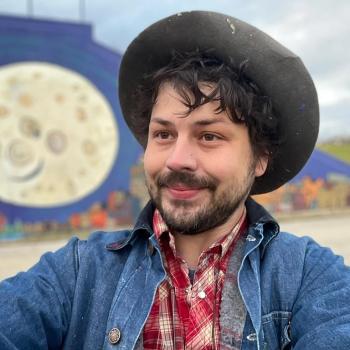 artist Charlie Haskins in front of mural