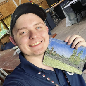 Sullivan Potter holding painted art.