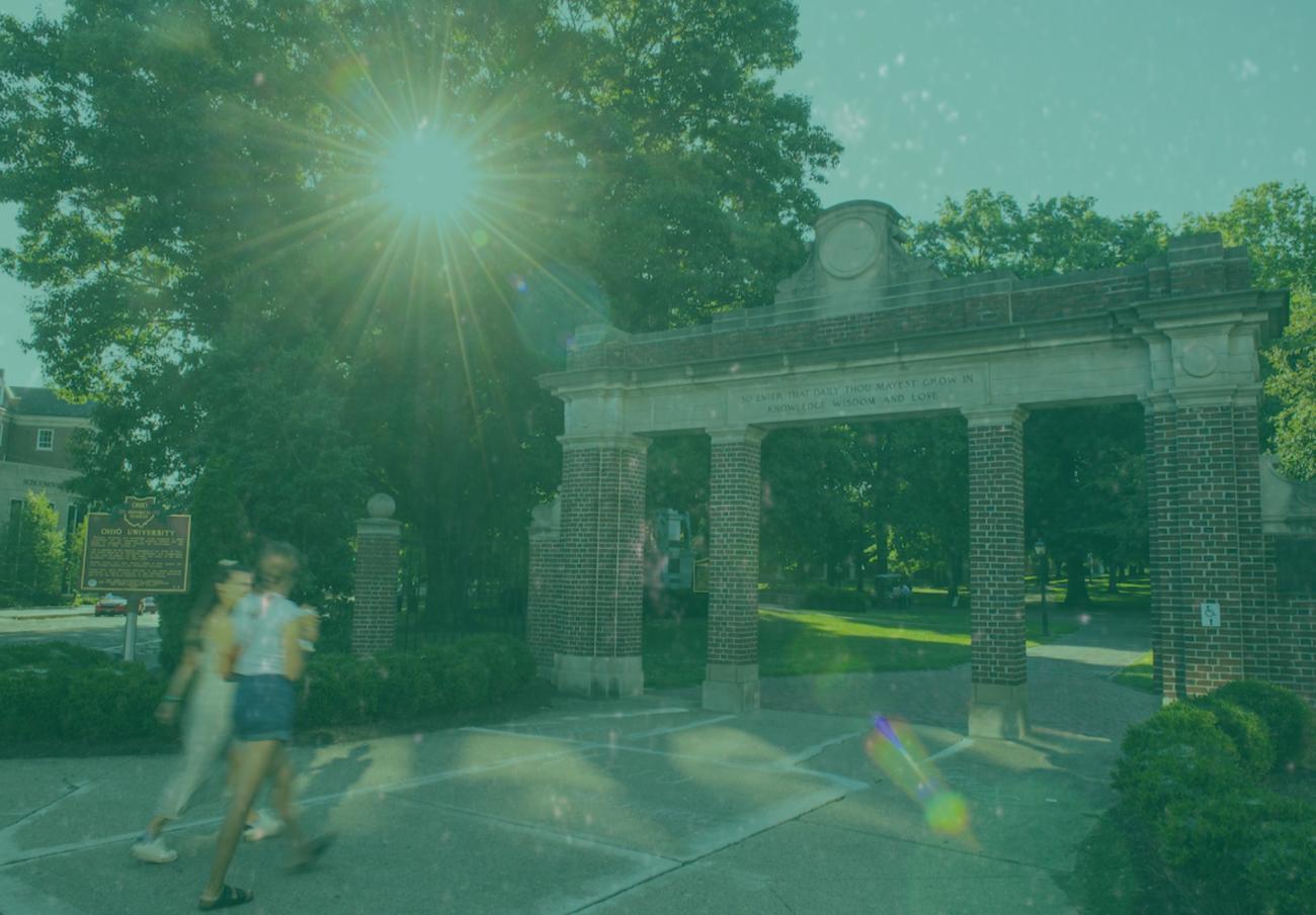 Two students walking through gateway.