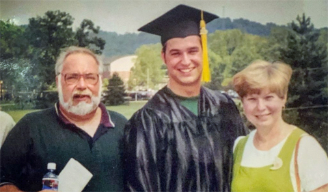 Ryan Phillips in a cap and gown with his parents