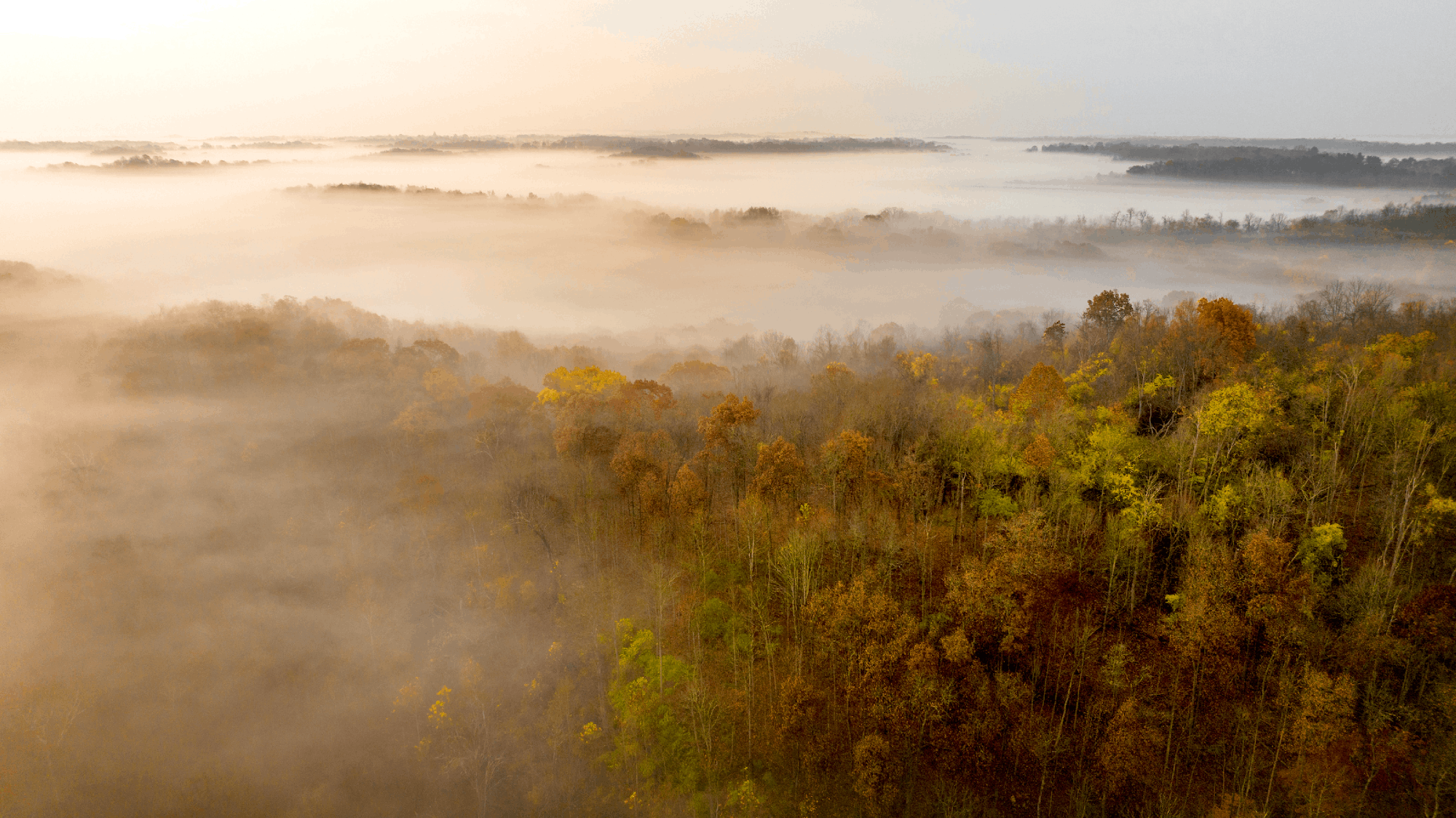 The sun rises over fog on the hills surrounding the Athens campus. 