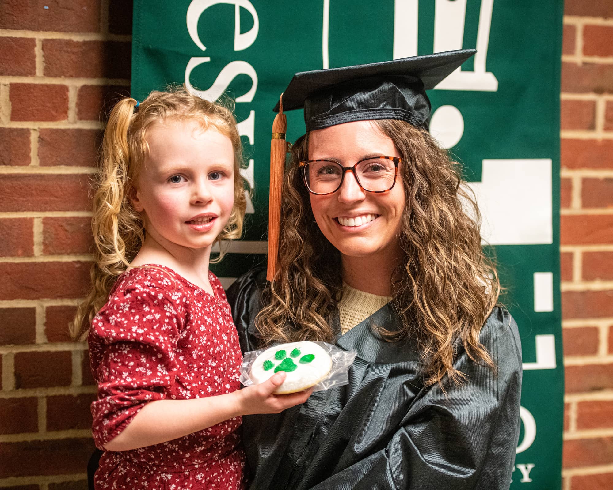 A recent graduate poses for a photo with their daughter following the Graduation Recognition Ceremony at the Zanesville Campus. 