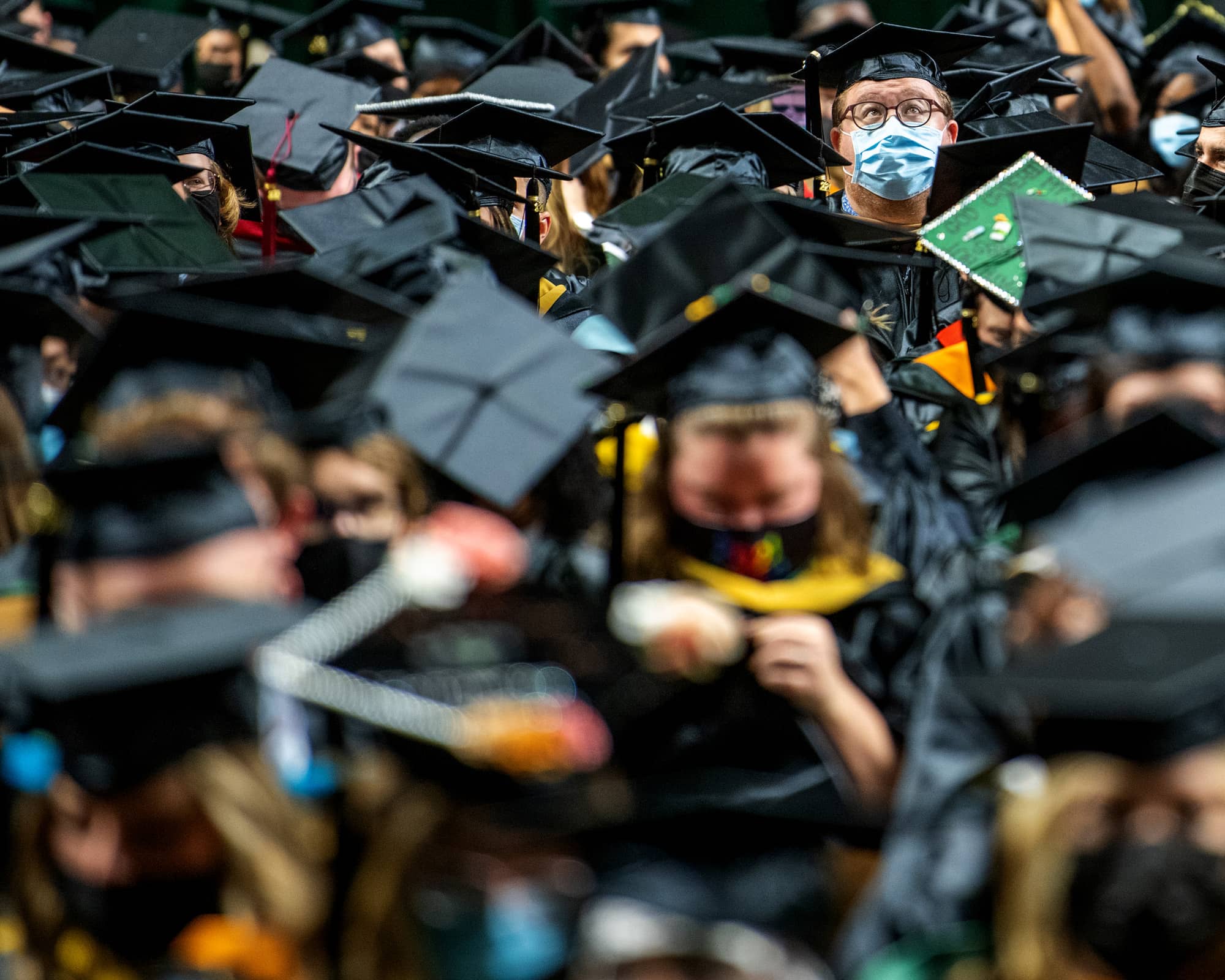 A student looks to audience in the Convocation Center during the Fall Commencement 2021 at the Athens Campus.