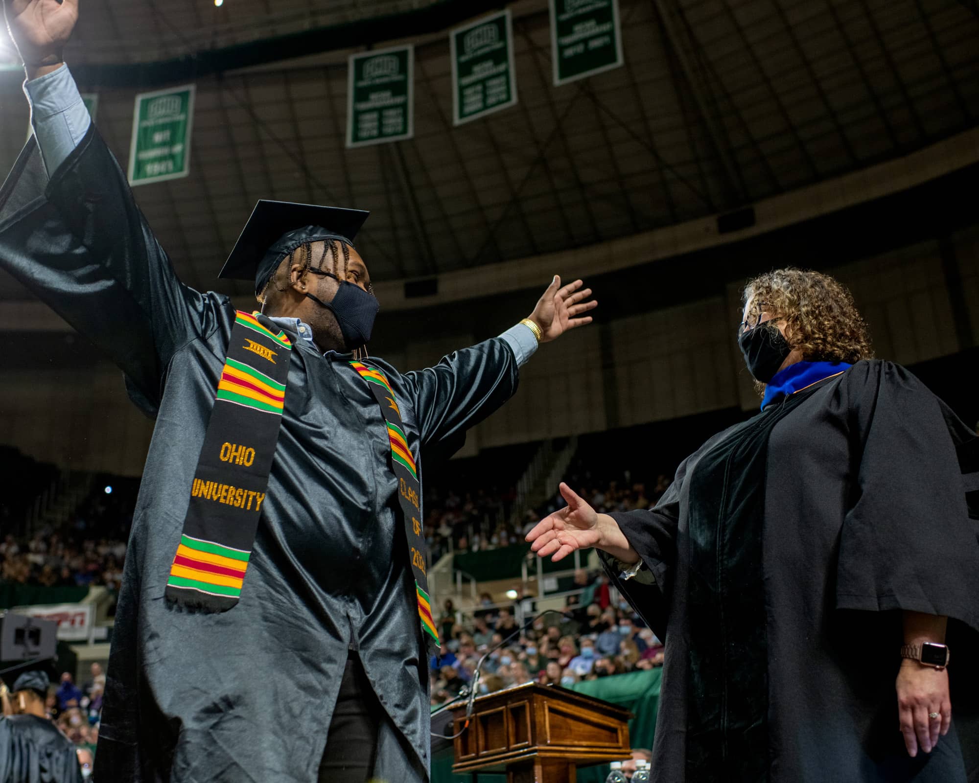 A student celebrates as Dean Jackie Rees Ulmer offers a congratulatory hand during Fall Commencement 2021 at the Athens Campus.