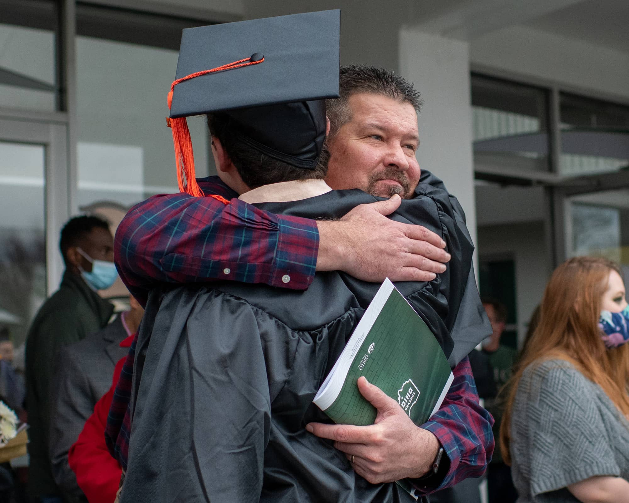 A graduate receives a hug after the Fall Commencement 2021 at the Athens Campus. 