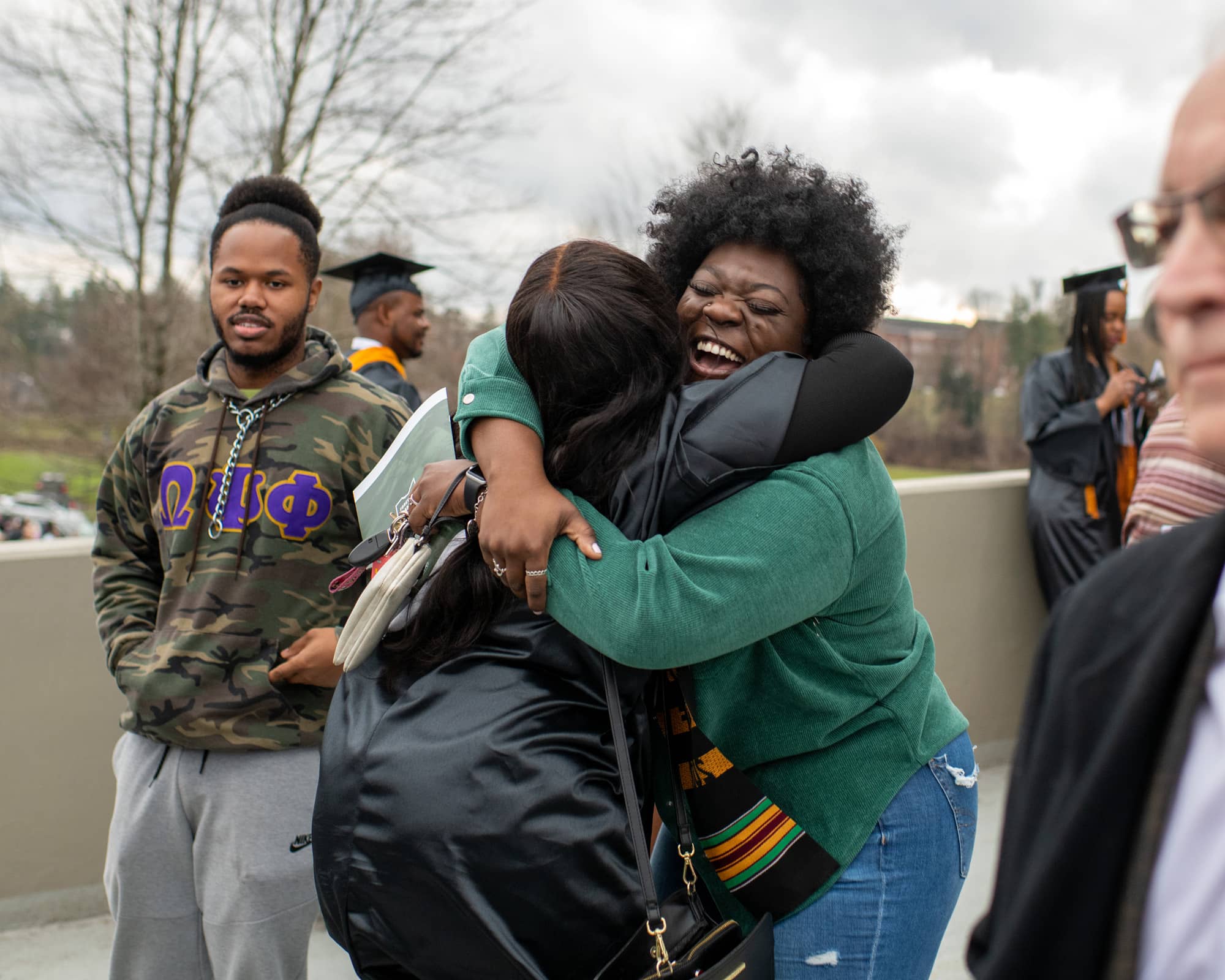 A graduate celebrates with a hug after the Fall Commencement 2021 at the Athens Campus. 