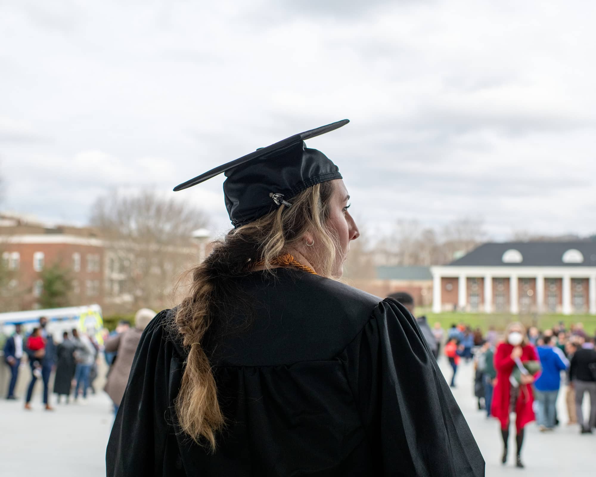 A recent graduate observes the crowd of families, friends and loved ones after the Fall Commencement 2021 at the Athens Campus.