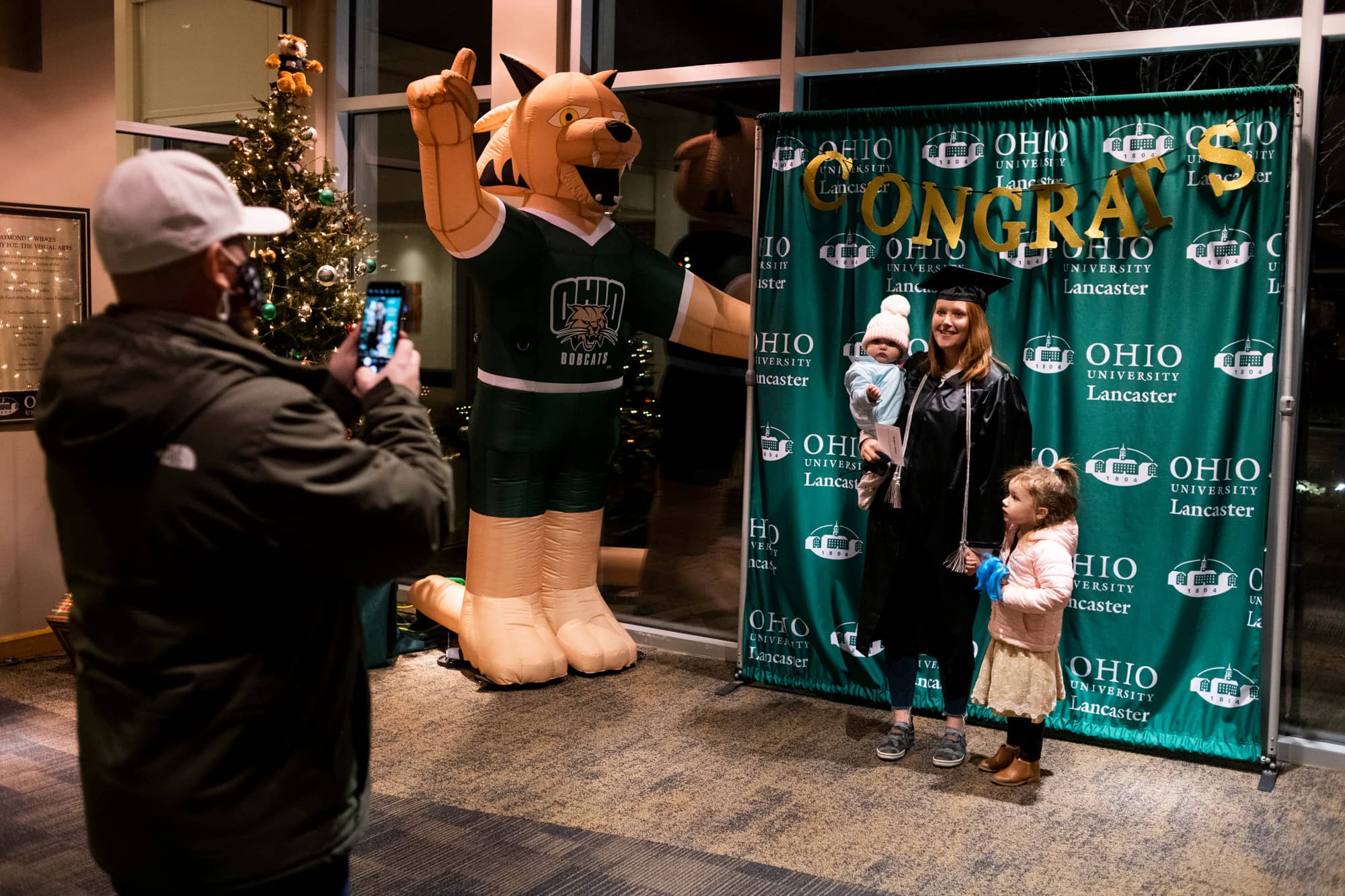 A recent graduate poses for a photo with their family following the Graduation Recognition Ceremony at the Lancaster Campus. 