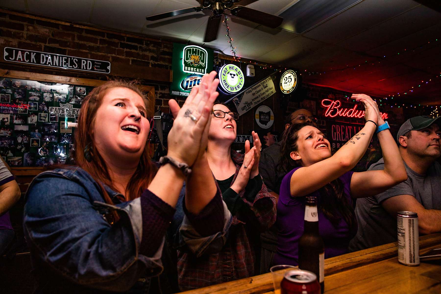 Patrons at a bar clapping hands