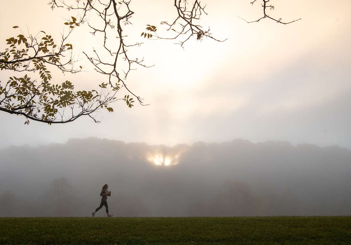 A jogger cuts through the fog on the Hockhocking Adena Bike path