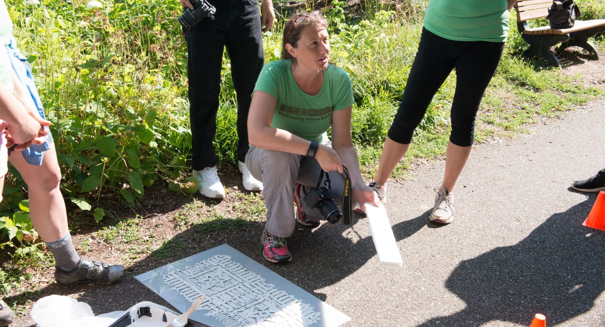 Annie Laurie Cadmus, director of sustainabilty at Ohio University, gives volunteers instructions before painting mile markers on the HockHocking Adena Pathway. © Ohio University / Photo by Kaitlin Owens
