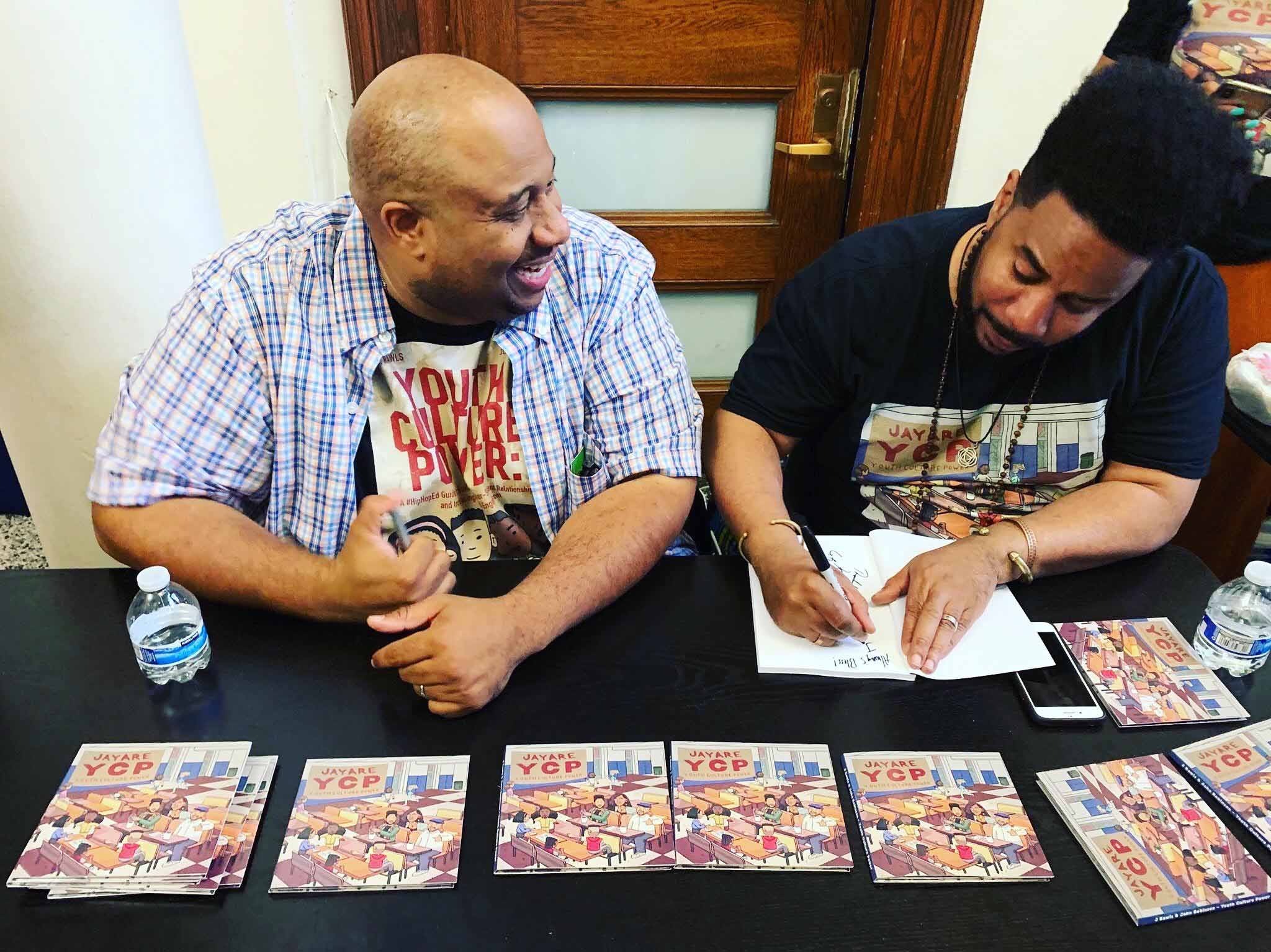 Dr. Jason Rawls and co-author John Robinson autograph copies of their book, Youth Culture Power: A #HipHopEd Guide to Building Teacher-Student Relationships and Increasing Student Engagement. Photo courtesy of Dr. Rawls