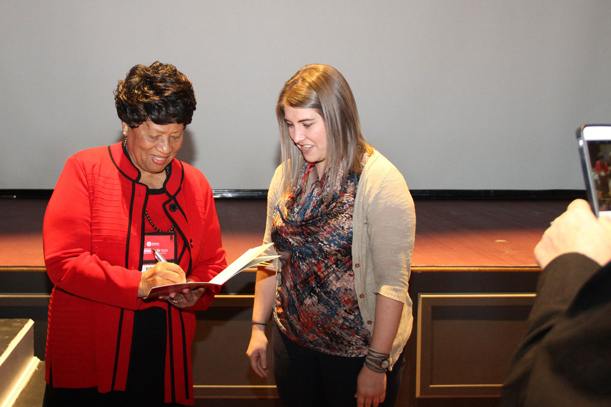 Elders signing an autograph for a student conference attendee