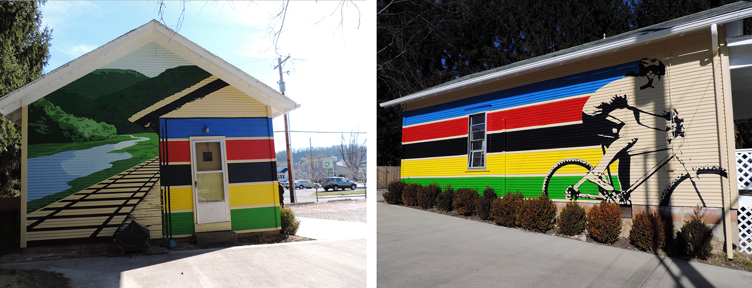 Two painted murals. Ove of a train track by the river, and one of a cyclist.