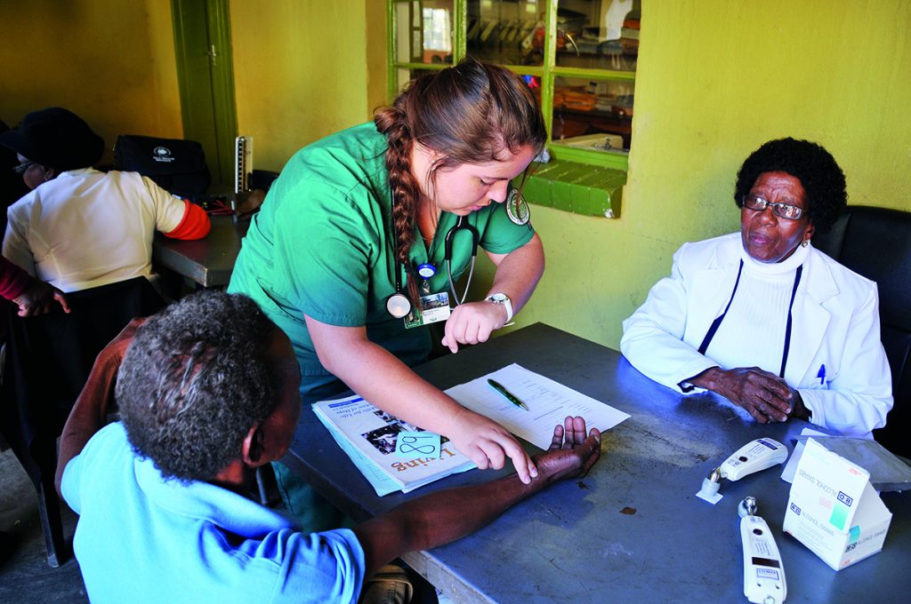 OHIO student Elena Kaiser, BSN ’17, is led by health care professionals in Botswana at a clinic during GHI’s June 2016 trip to the African country. Photo by Gillian Ice