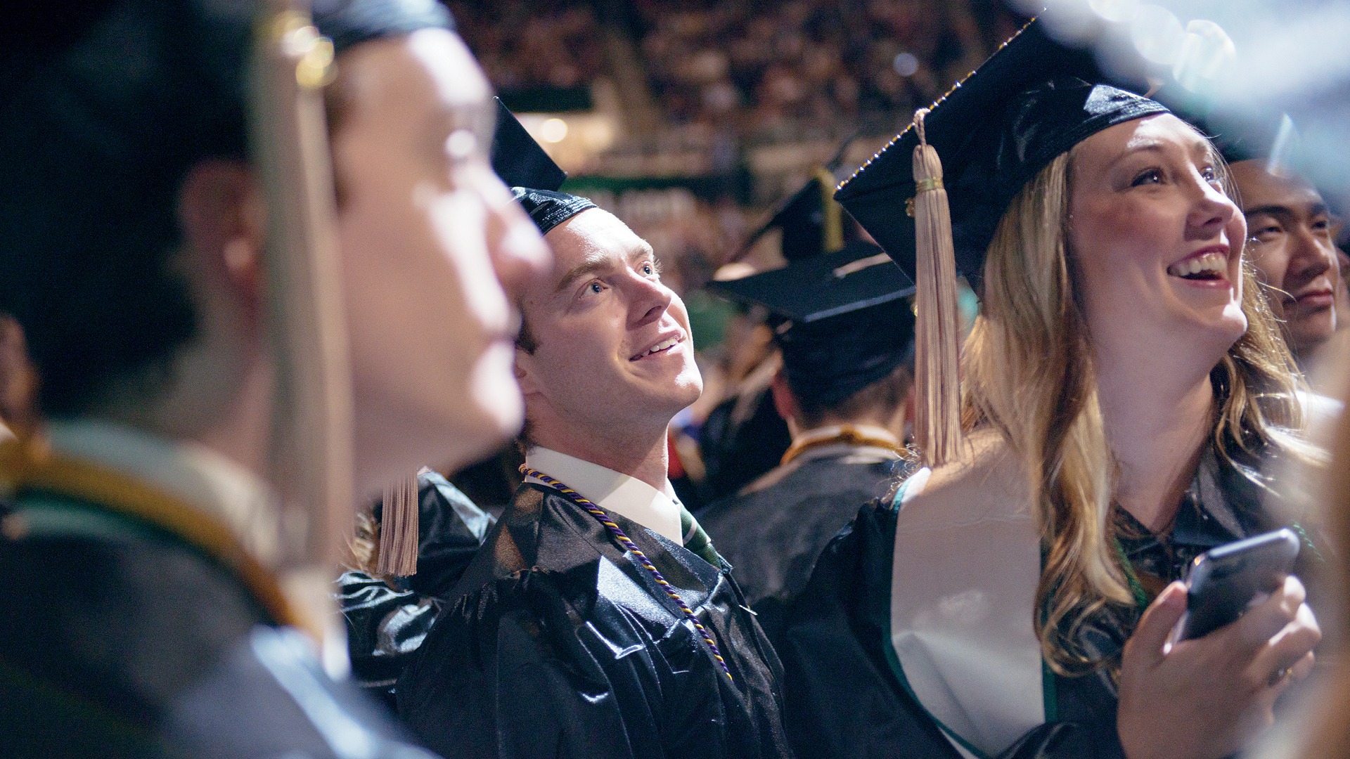 3 graduates smiling during commencement