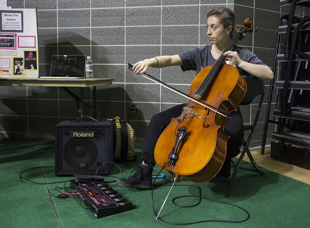 Lily Gelfand, a dance major in the Honors Tutorial College, demonstrates how to use a loop-pedal system at the 2016 Student Research and Creative Activity Expo. Gelfand uses the pedal to loop her live cello music during dance classes and performances. Photo by Emily Matthews, BSVC ’18