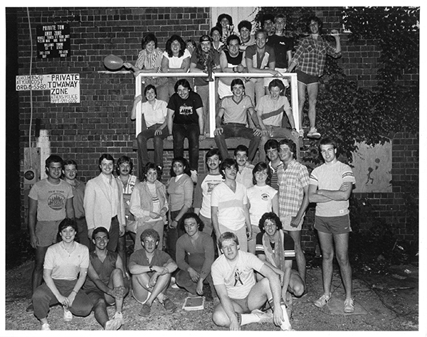 class picture students sitting in the front, a middle row, and students leaning on a railing in the back