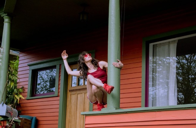 Dancer posing alone on her porch railing