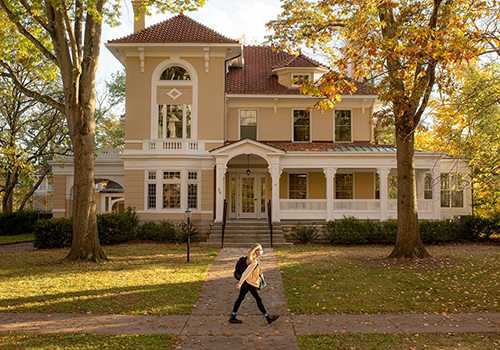 student walking past 29 park place on fall day