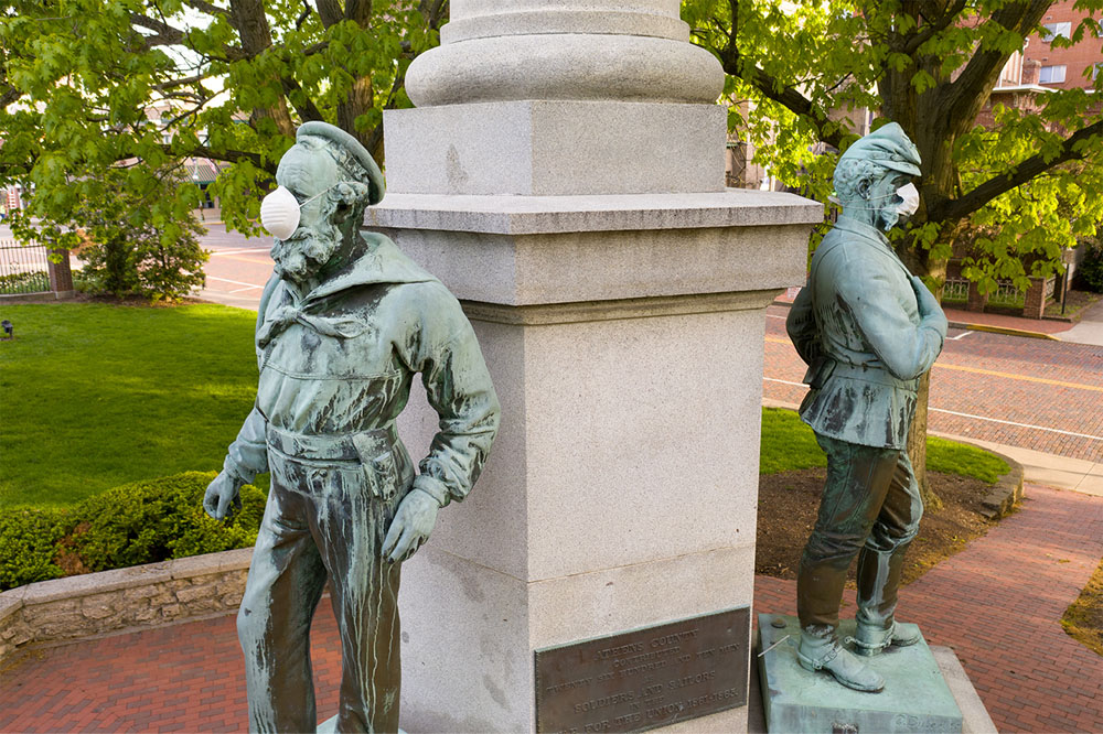 Two statues of sailors wearing covid masks on campus.