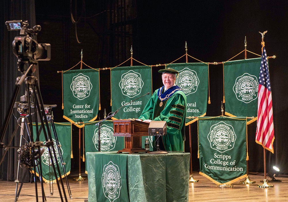 President Nellis stands at the podium during a graduation ceremony