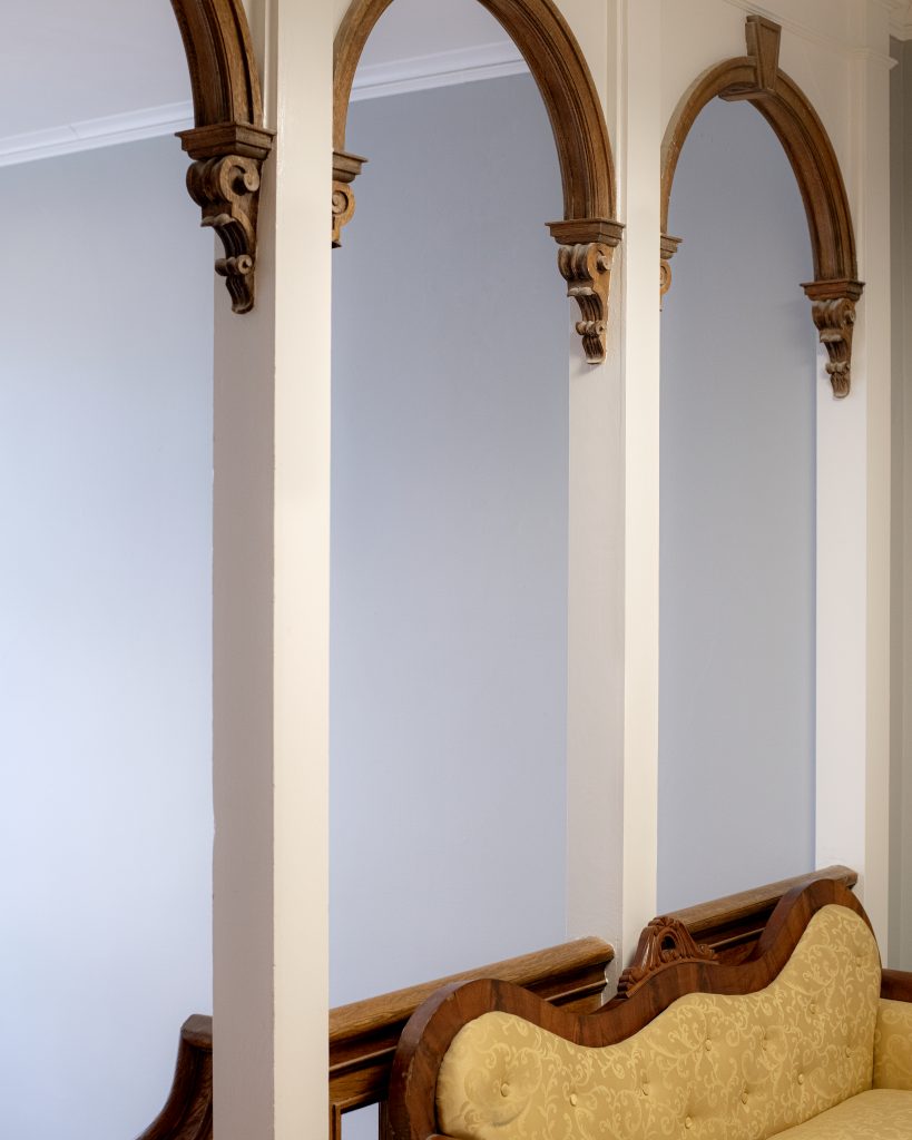 wooden arches behind the chair in the upstairs of 29 Park Place
