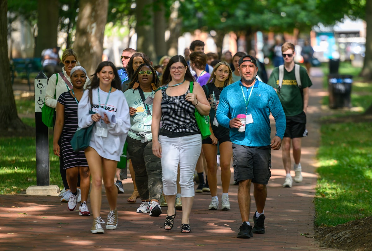 A group of incoming Ohio University students walk on College Green at Bobcat Student Orientation