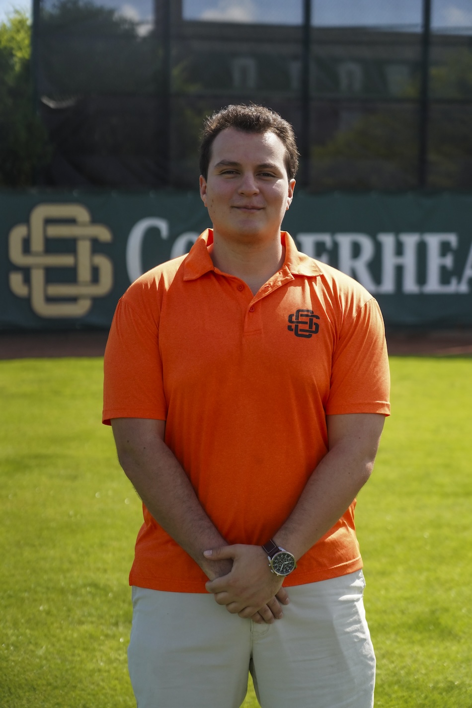 Roberto Lemus poses for a portrait wearing an oranger Copperheads polo shirt