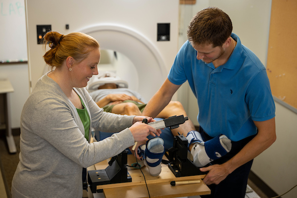 Grooms works with a patient in an MRI machine.