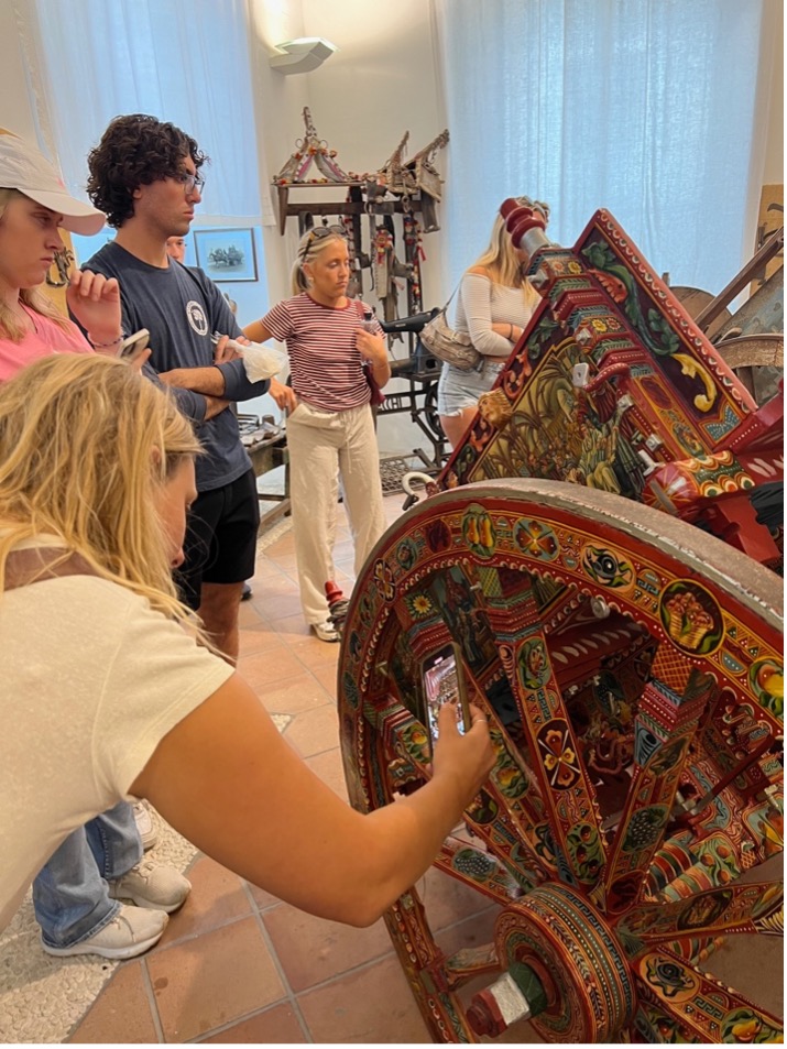 a woman bends over to take a photo of a colorful cart