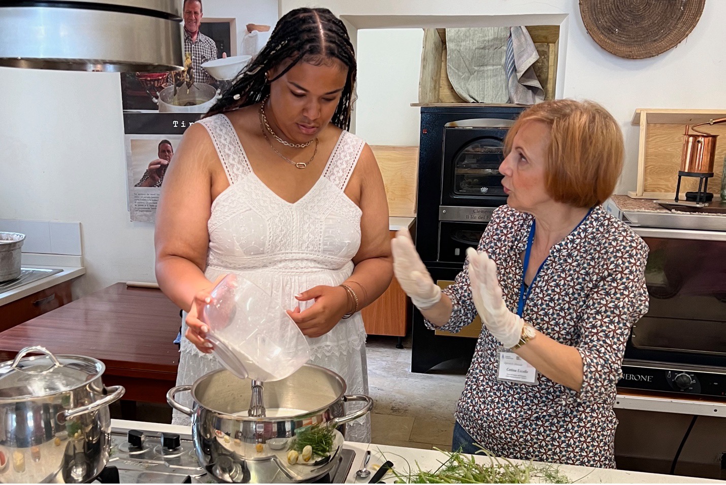 A woman speaks to a student in a kitchen