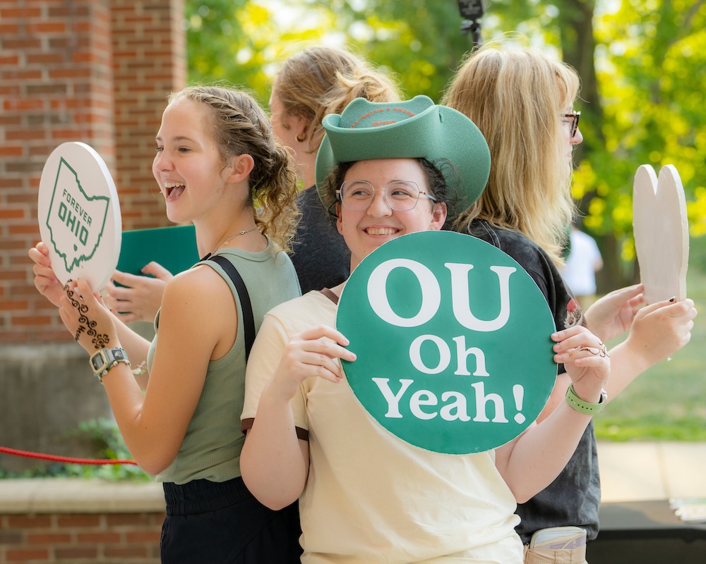 Students stand back-to-back posing for a picture, holding "OU Oh Yeah!" and "Forever OHIO" signs