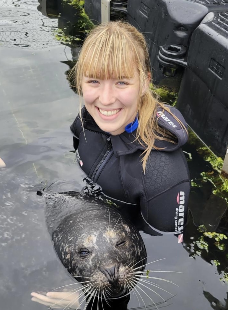 Student poses with the seal she is studying 