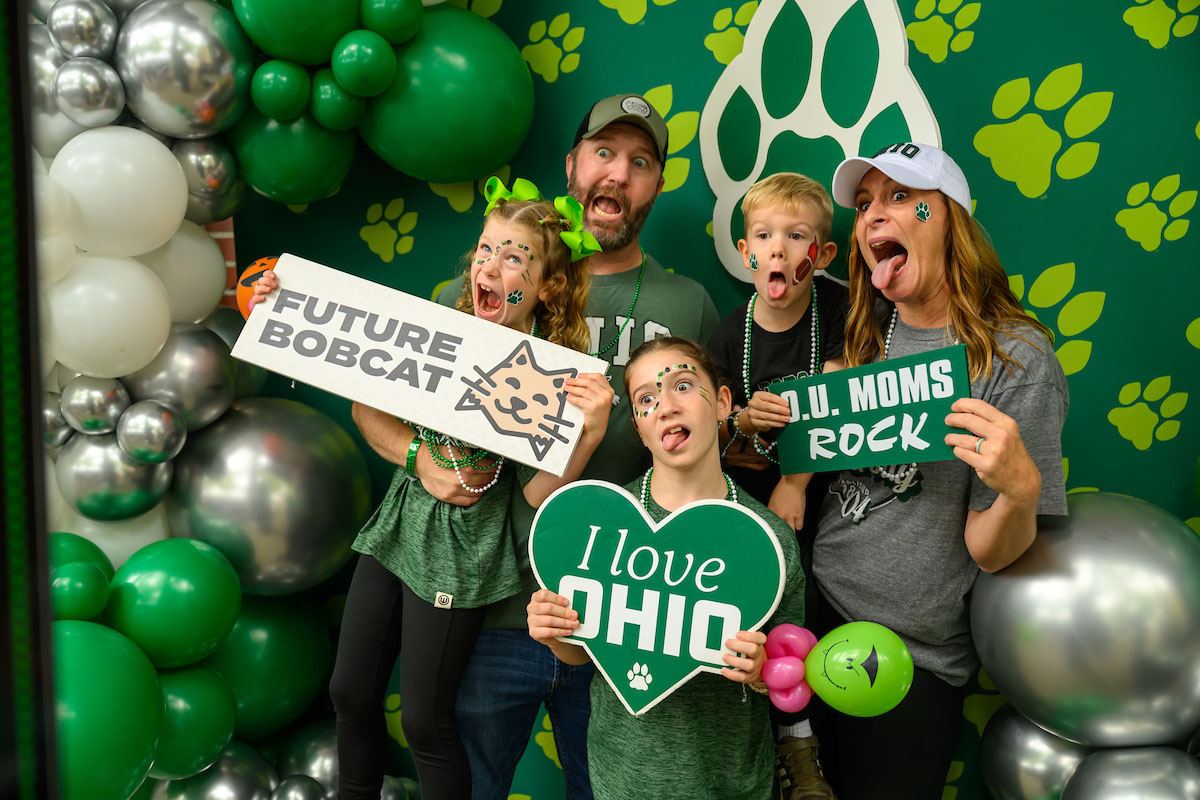 A family of future Bobcats pose for the camera at the Bobcat Family tent