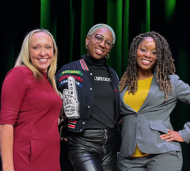 Panelists pose for a photo on a stage